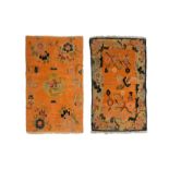 TWO TIBETAN ORANGE GROUND SMALL WOOL RUGS