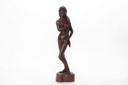 A BALINESE CARVED HARDWOOD FIGURE OF A FEMALE NUDE