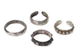 A GROUP OF FOUR SILVER / WHITE METAL BANGLES