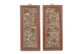 A PAIR OF CARVED AND POLYCHROME DECORATED WOOD PANELS