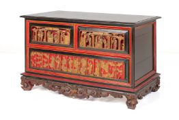 A RED, BLACK AND GILT CHEST OF DRAWERS