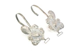 A PAIR OF SILVER WEDDING BED CURTAIN HOOKS