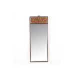 A TALL RECTANGULAR WALL MIRROR WITH CARVED PANEL