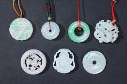 A GROUP OF SEVEN CARVED JADE DISCS AND PENDANTS