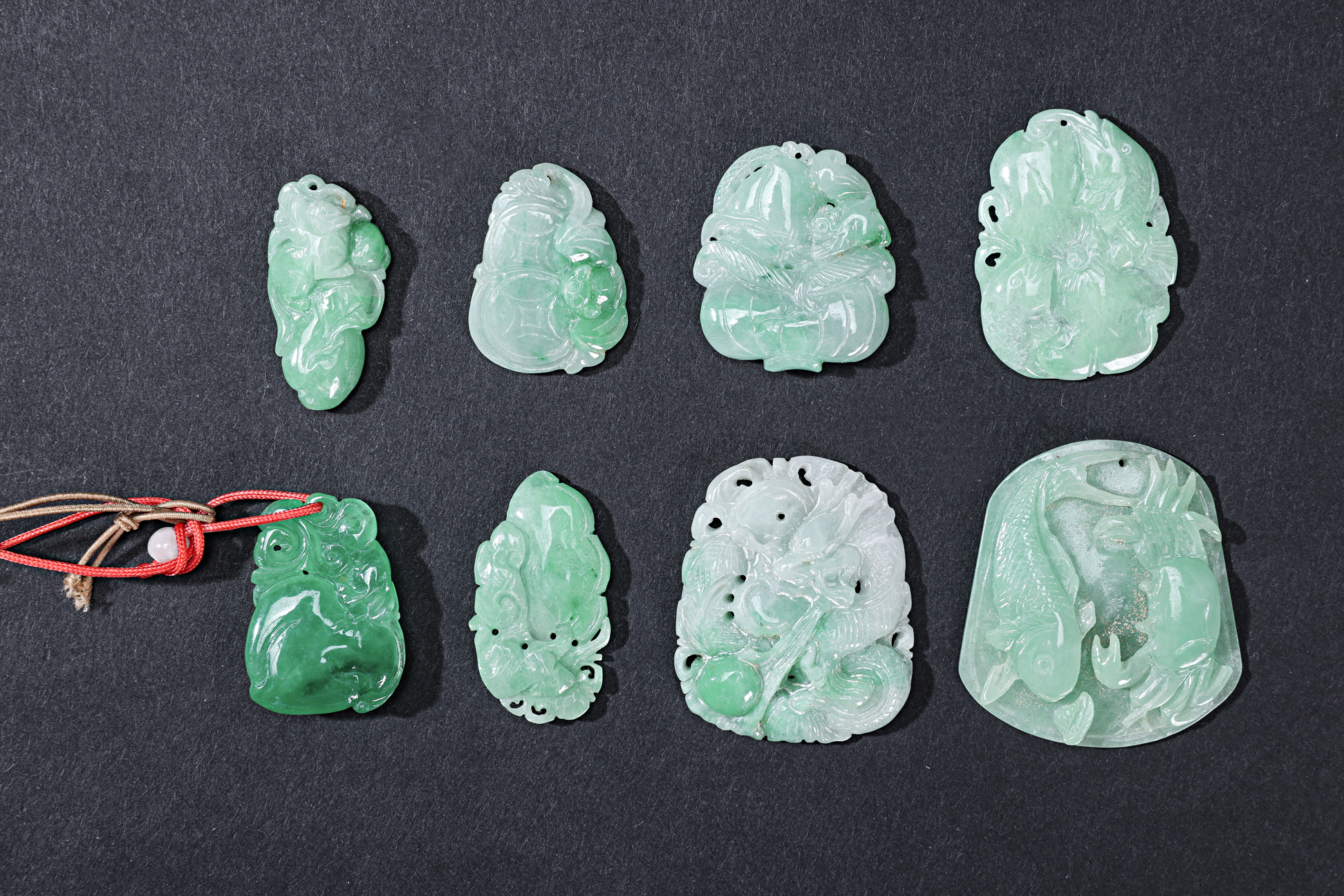 A GROUP OF EIGHT CARVED JADE PENDANTS