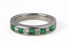 AN EMERALD AND DIAMOND HALF ETERNITY RING