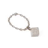 A CARTIER DICE CHARM ON A BASE METAL BRACELET