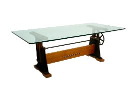 AN INDUSTRIAL GLASS TOPPED HEIGHT ADJUSTABLE DESK