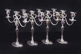 A SET OF FOUR ENGLISH SILVER-PLATED THREE LIGHT CANDELABRA