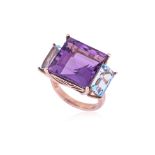 AN AMETHYST AND TOPAZ THREE STONE RING