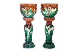 A PAIR OF GLAZED DRAGON JARDINIERES ON STANDS