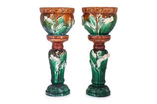 A PAIR OF GLAZED DRAGON JARDINIERES ON STANDS