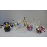 A collection of perfume atomisers and other glass bottles, including one silver topped