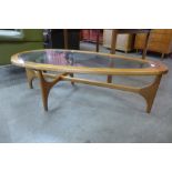 A Stonehill Stateroom teak and glass topped tear shaped coffee table