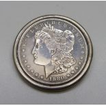 An 1880 United States silver dollar in a white metal brooch mount, 37.7g