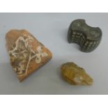 A Paleolithic hand axe, a section of a tile from Bretby House, and a cast bronze weight