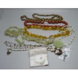 A collection of gemstone jewellery including jadeite pendants and other hard stones