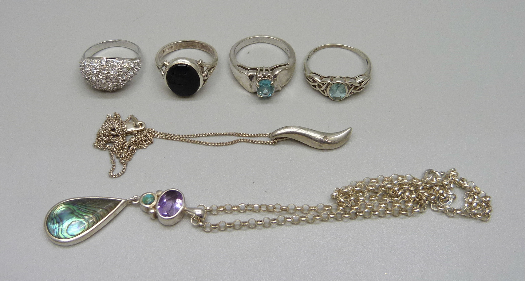 Four silver rings and two silver pendants and chains