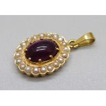 An 18ct gold pendant set with a cabochon red stone and seed pearls, 6g, 15mm wide