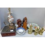 A Japanese lacquered box, a table lamp, a collection of carved wooden oriental figures and brass