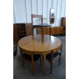 A Nathan teak circular extending dining table and four chairs