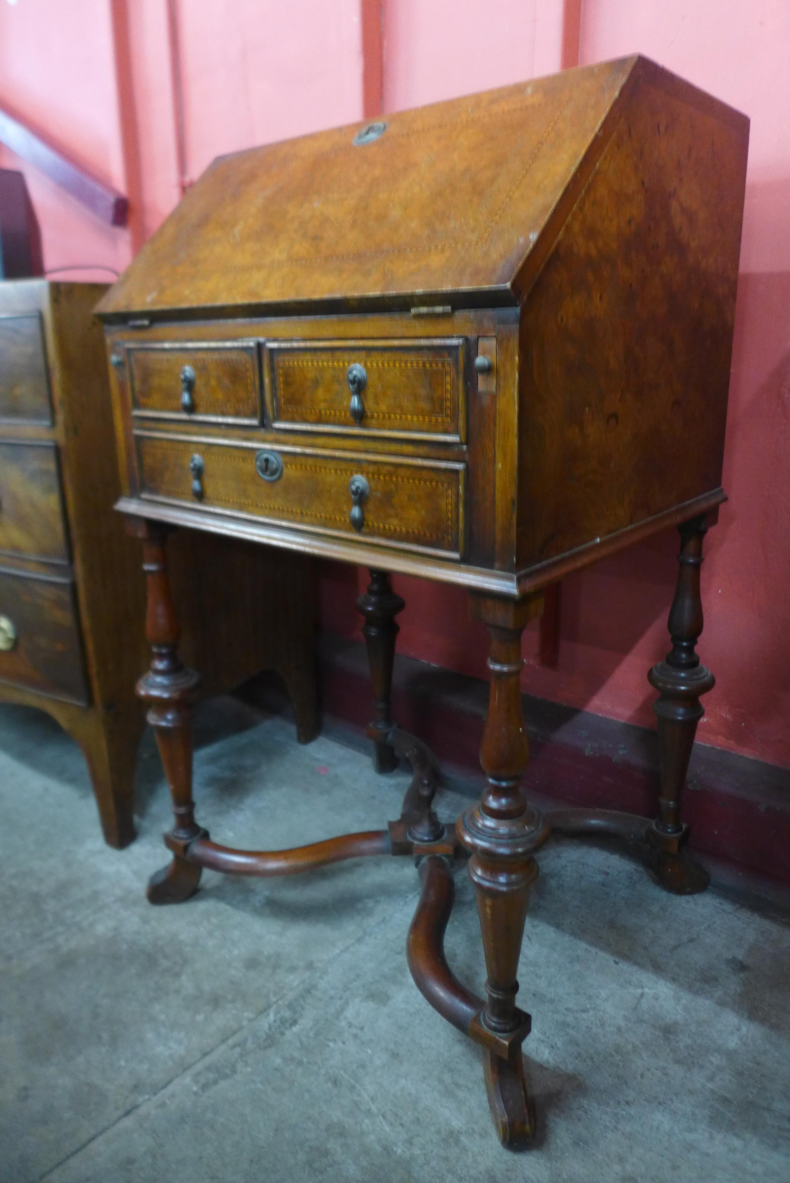 A George I style inlaid burr walnut bureau de dame