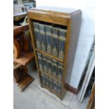 A small oak bookcase containing, with fifteen Charles Dickens novels