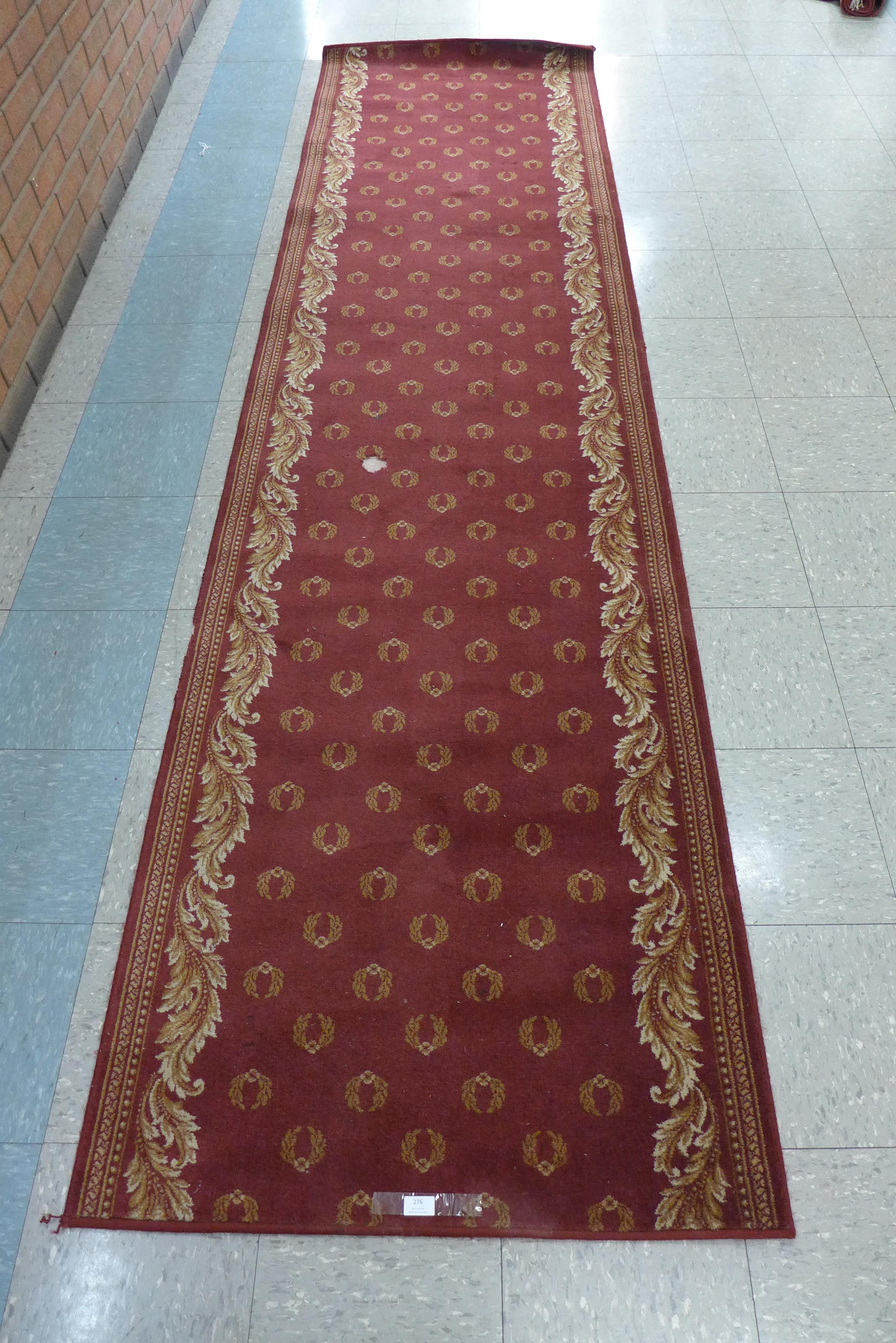 A red ground Wilton runner rug, 91 x 210cms