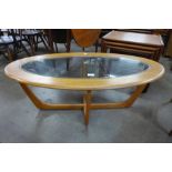 A teak and glass topped oval coffee table