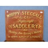A painted wooden sign, Whippy Steggall & Co., Lightweight Saddlery