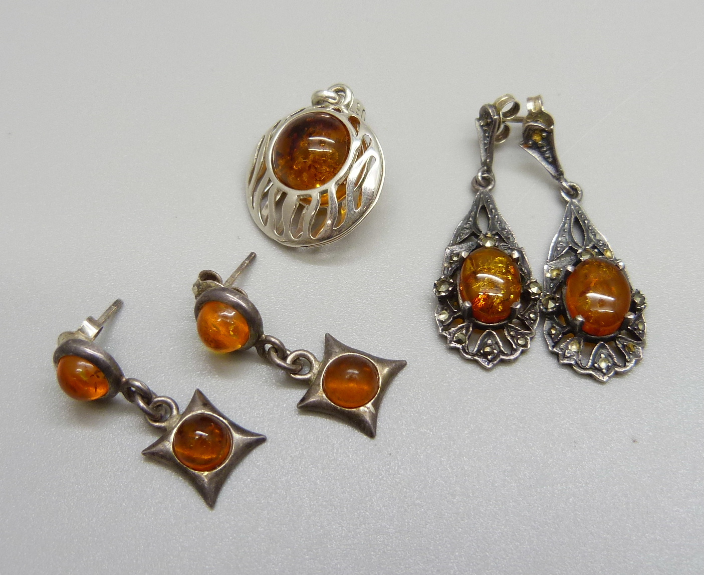 Two pairs of amber earrings and one pendant, one not hallmarked, tests as silver