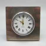 A small desk clock with silver front, movement loose, 25cm wide