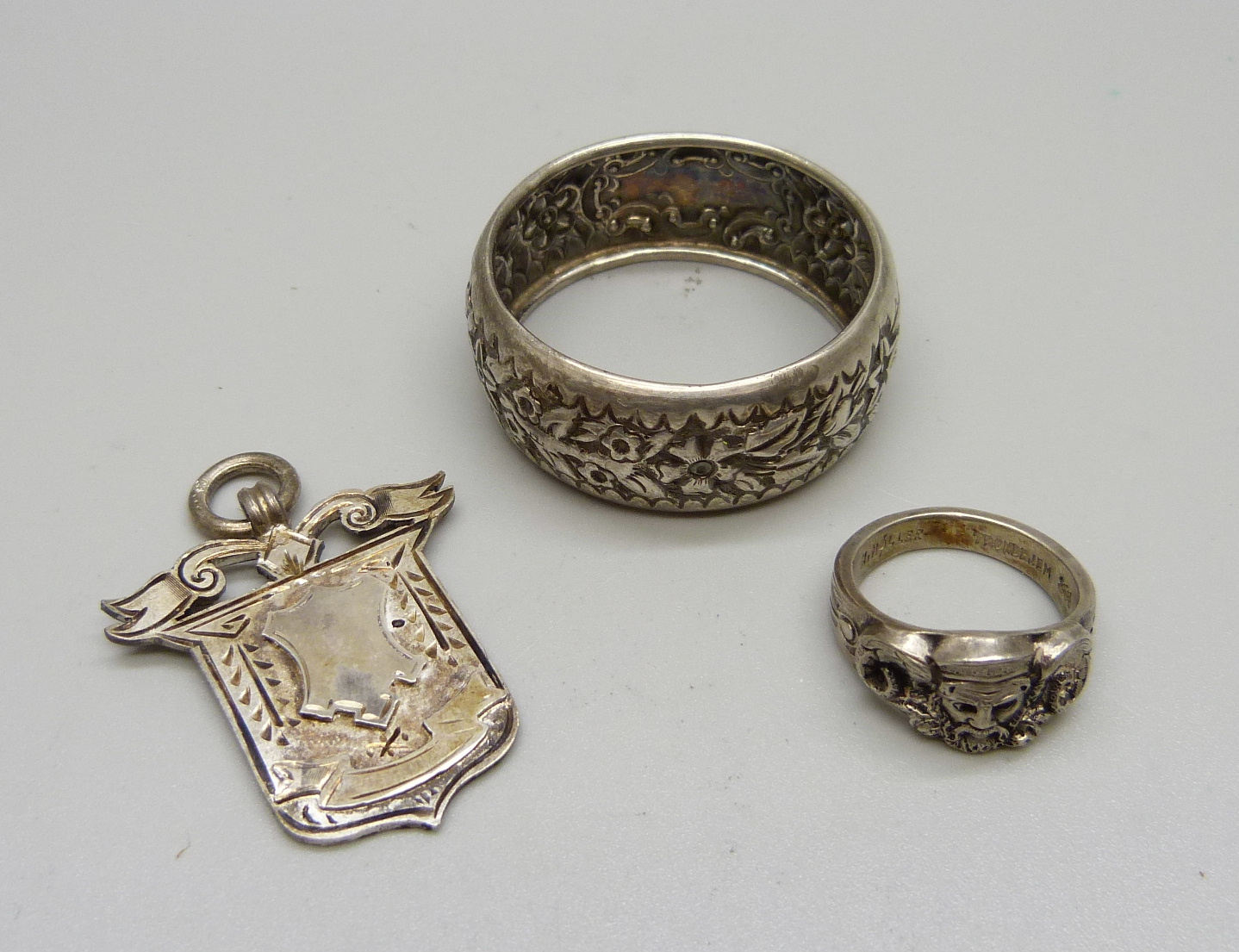 A silver ring, Moller, Trondhjem, P, a silver napkin ring and a late Victorian silver fob,