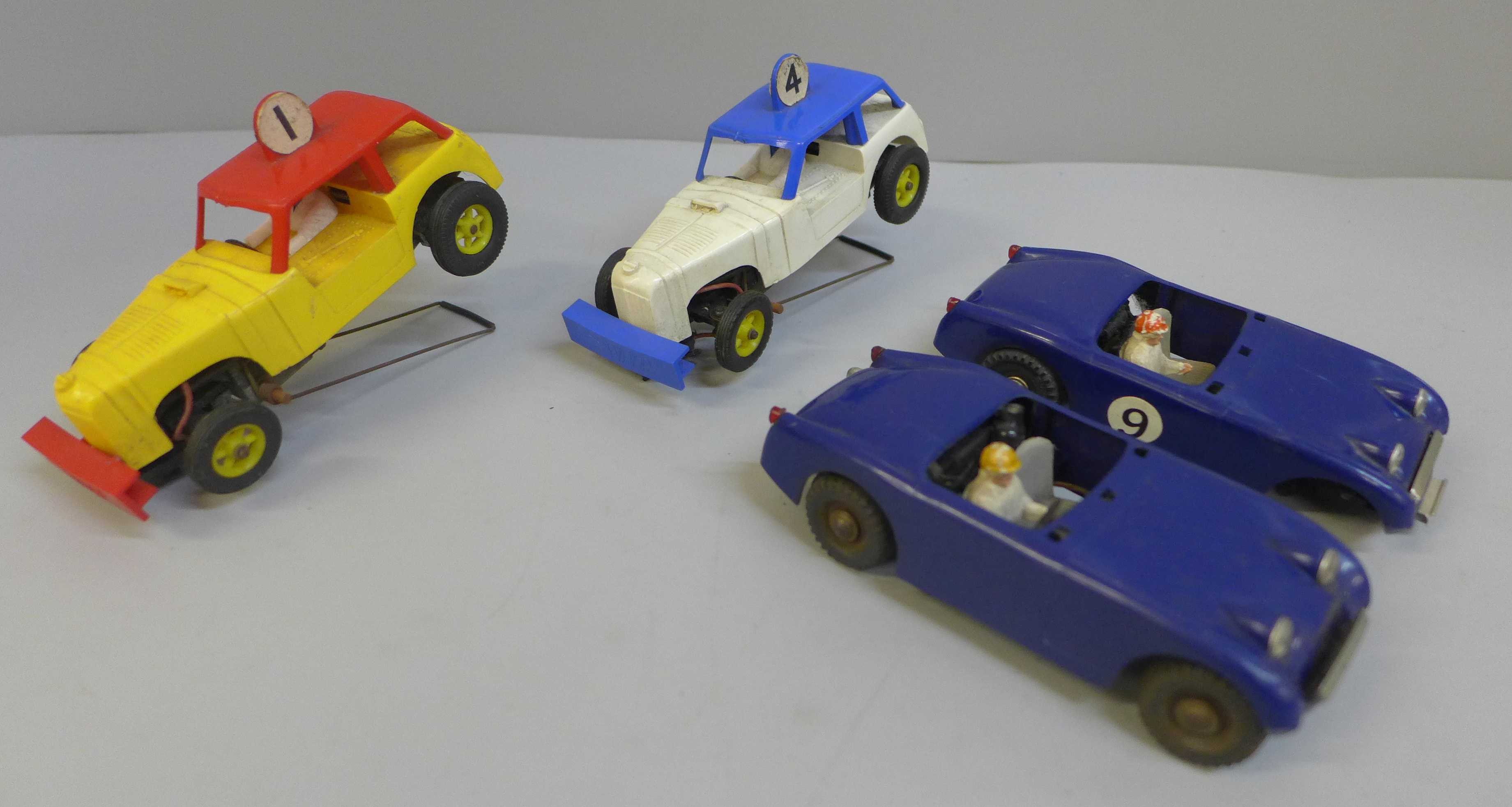 Four Victory Industries slot racing cars, one lacking wheel