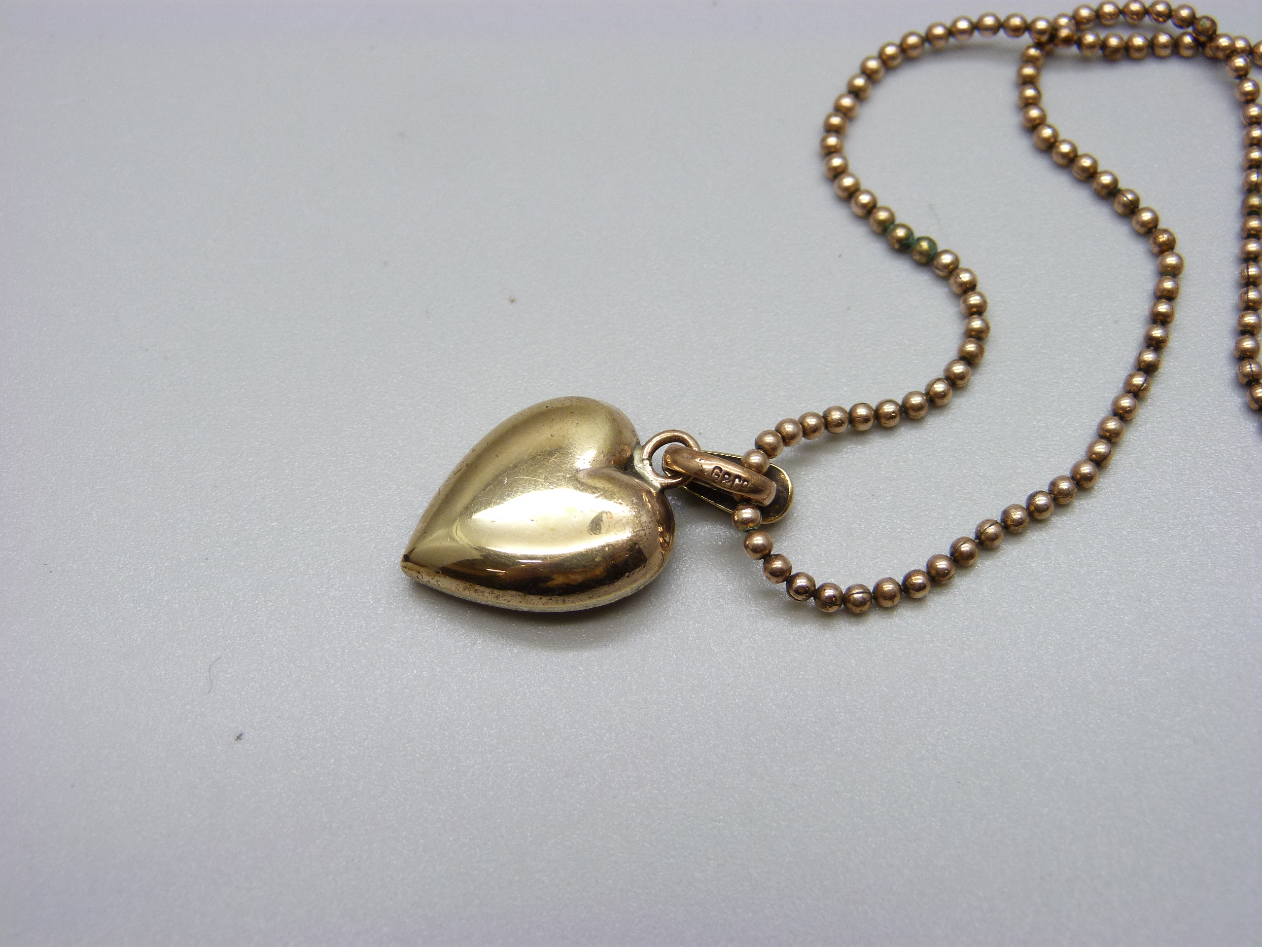 A yellow metal heart shaped pendant set with pearls, green and red stones on a 9ct gold bead - Image 3 of 4