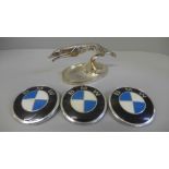 Three BMW car badges and a leaping greyhound car mascot