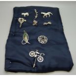 A collection of silver brooches, a silver stick pin, and a Napier horse brooch