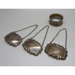 A set of three silver spirit labels and a silver napkin ring, 53g