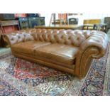 A chestnut brown leather Chesterfield settee