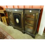 A French ebonised and gilt metal side cabinet, mounted with Sevres style porcelain plaques