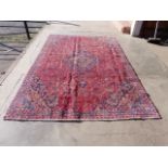 A Persian red ground Mashad rug, 305 x 207cms, a/f