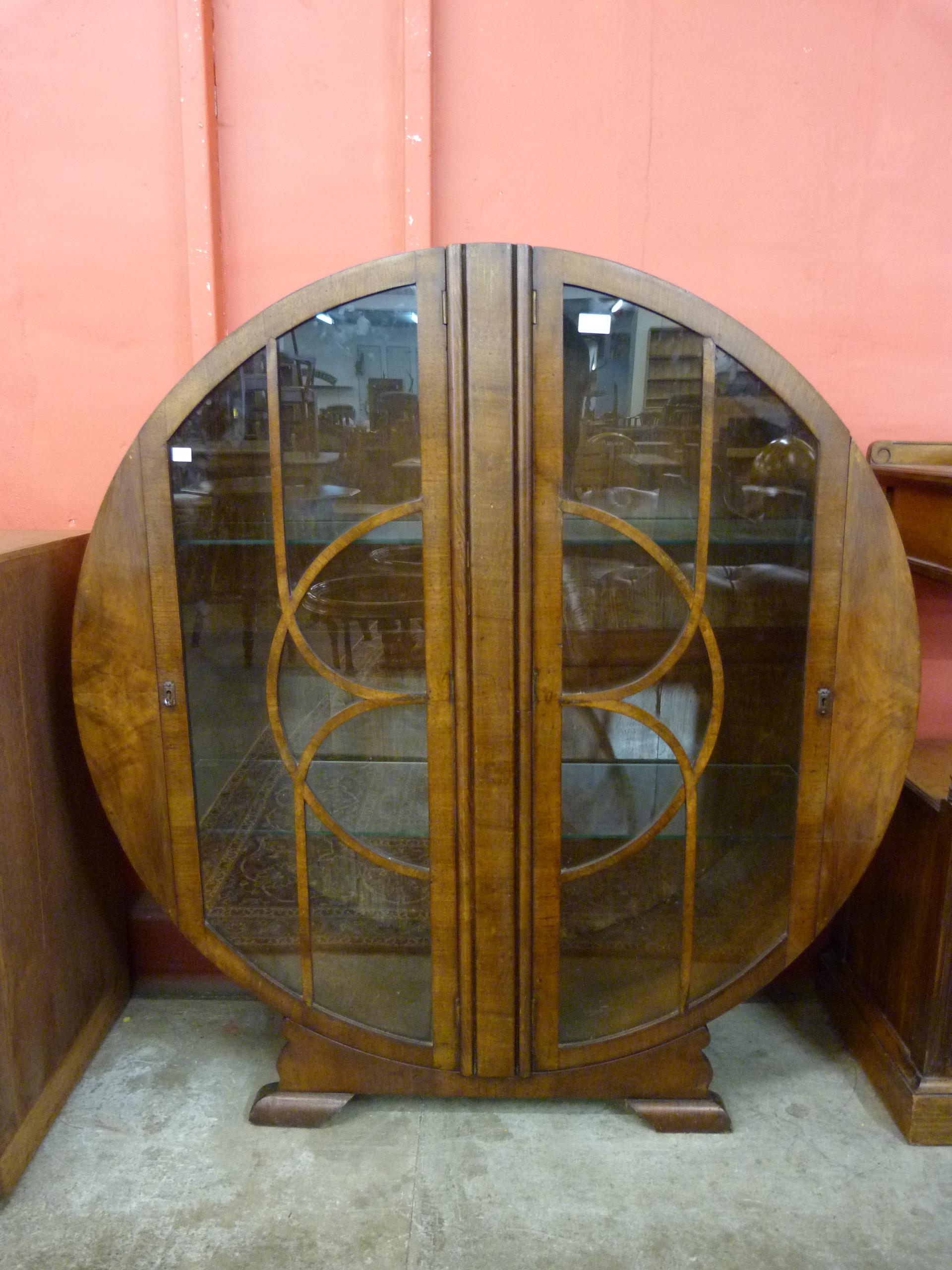 An Art Deco walnut circular two door display cabinet