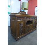 An Arts and Crafts carved oak sideboard