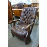 A Victorian style mahogany and brown leather buttonback open armchair