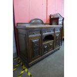 An Arts and Crafts carved oak sideboard