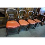 A set of four Victorian carved walnut balloon back dining chairs