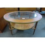 A circular teak and and glass topped coffee table