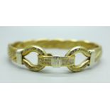 A 9ct gold 'Gucci' twist bangle with double loop design clasp and set with diamonds, bears TJ makers