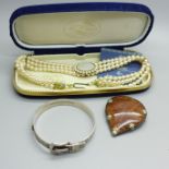 A silver buckle bangle, a goldstone pendant and a simulated pearl necklace