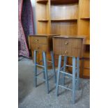 A pair of afromosia two drawer chests on metal stands